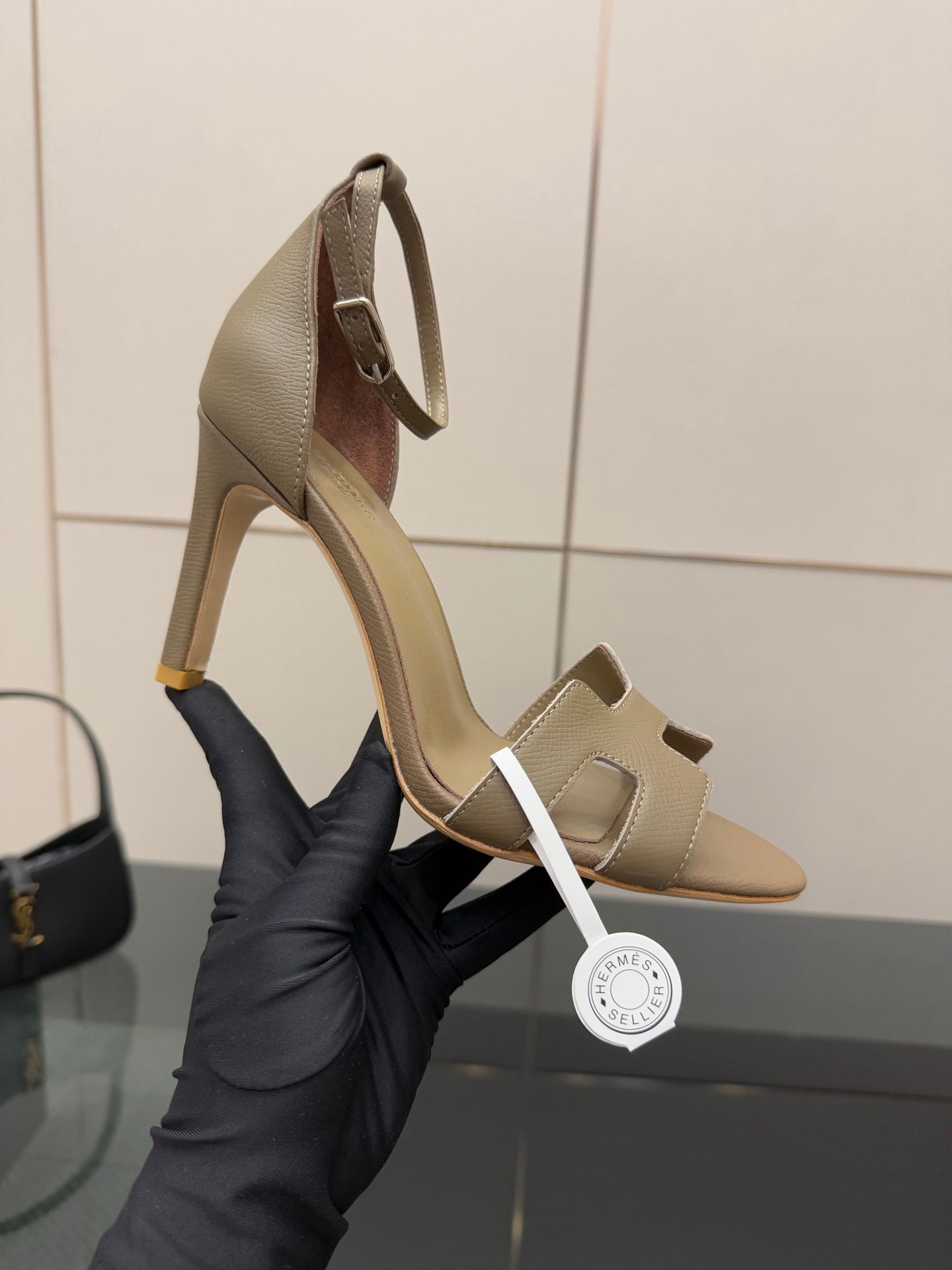Ladies heeled sandals in light gray, close-up of straps and curved heel