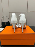 White heeled sandals showing heel backs and ankle strap
