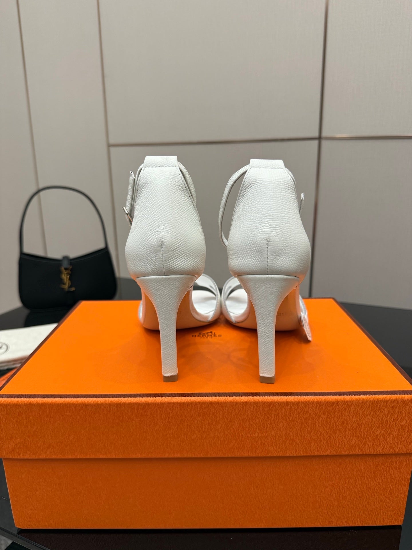 White heeled sandals showing heel backs and ankle strap