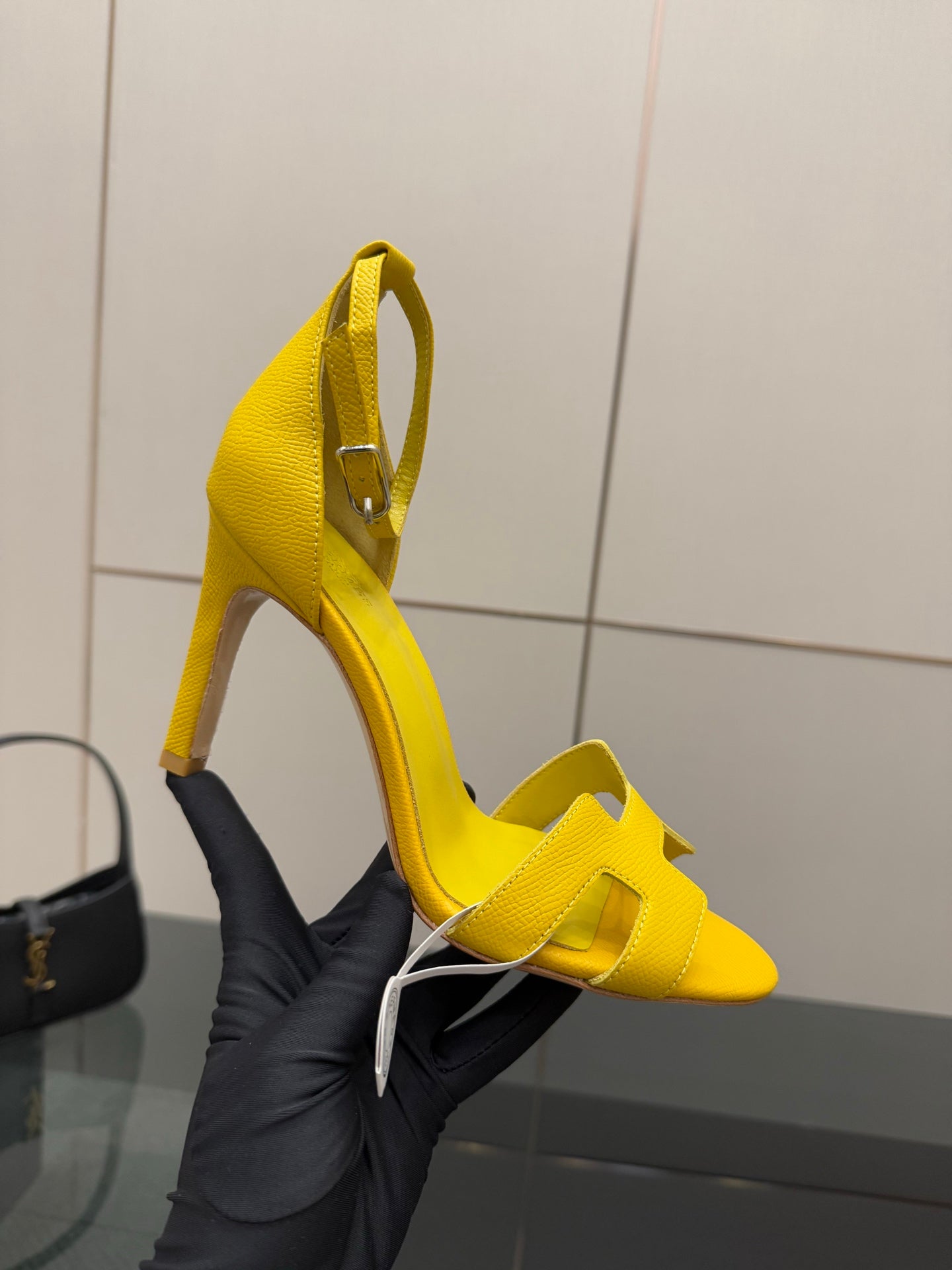 Hermes yellow heeled sandal on foot, close-up of ankle strap and heel
