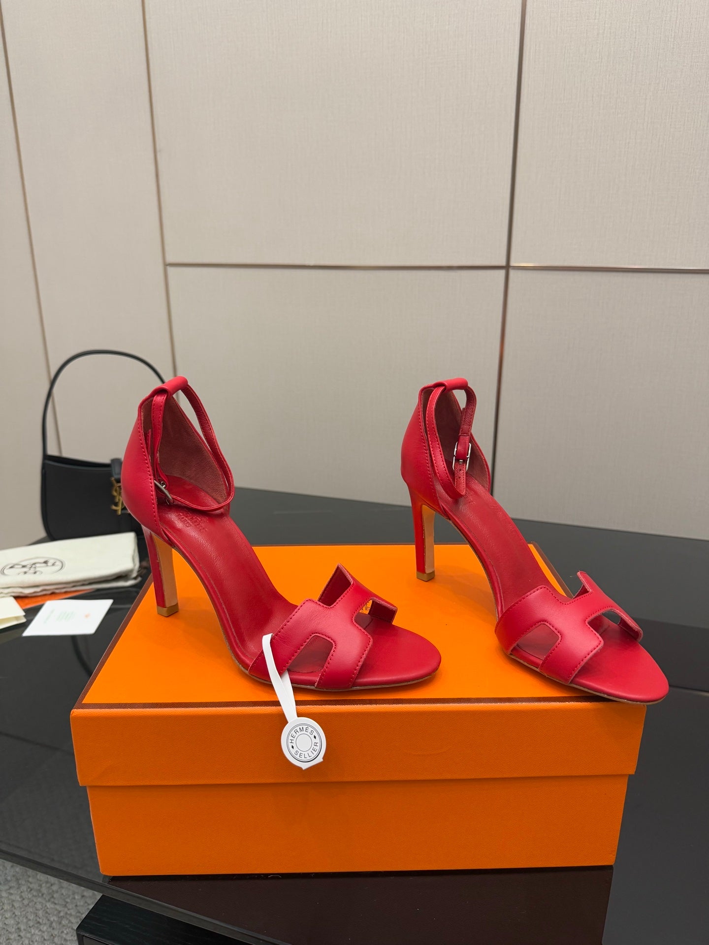 Hermes red strappy heeled sandals, angled view with slim stiletto heels