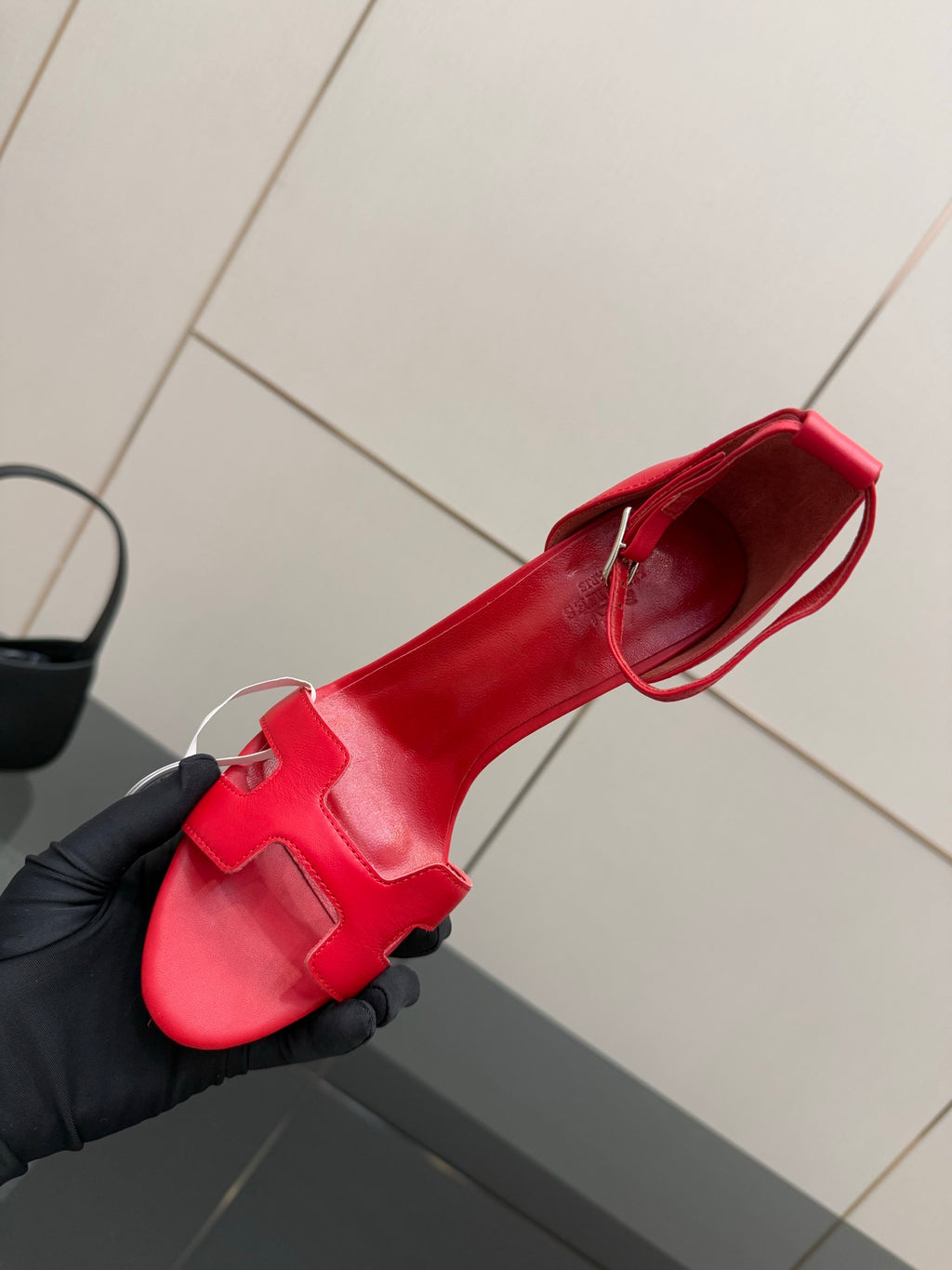 Hermes red slingback sandal in hand, showing open toe and strap across top