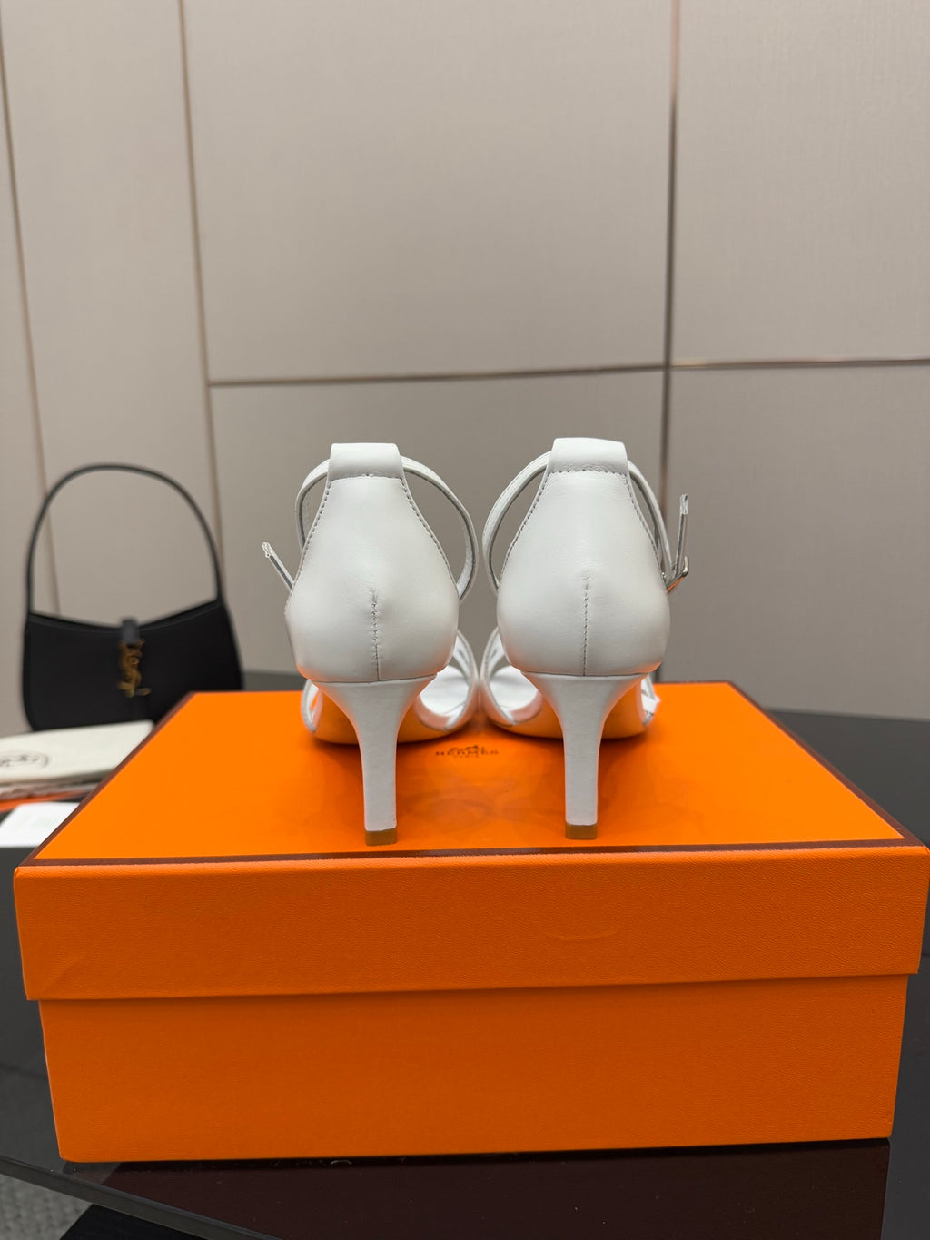 White heeled sandals shown from back, with ankle straps and thin heels