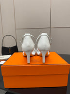 White heeled sandals shown from back, with ankle straps and thin heels