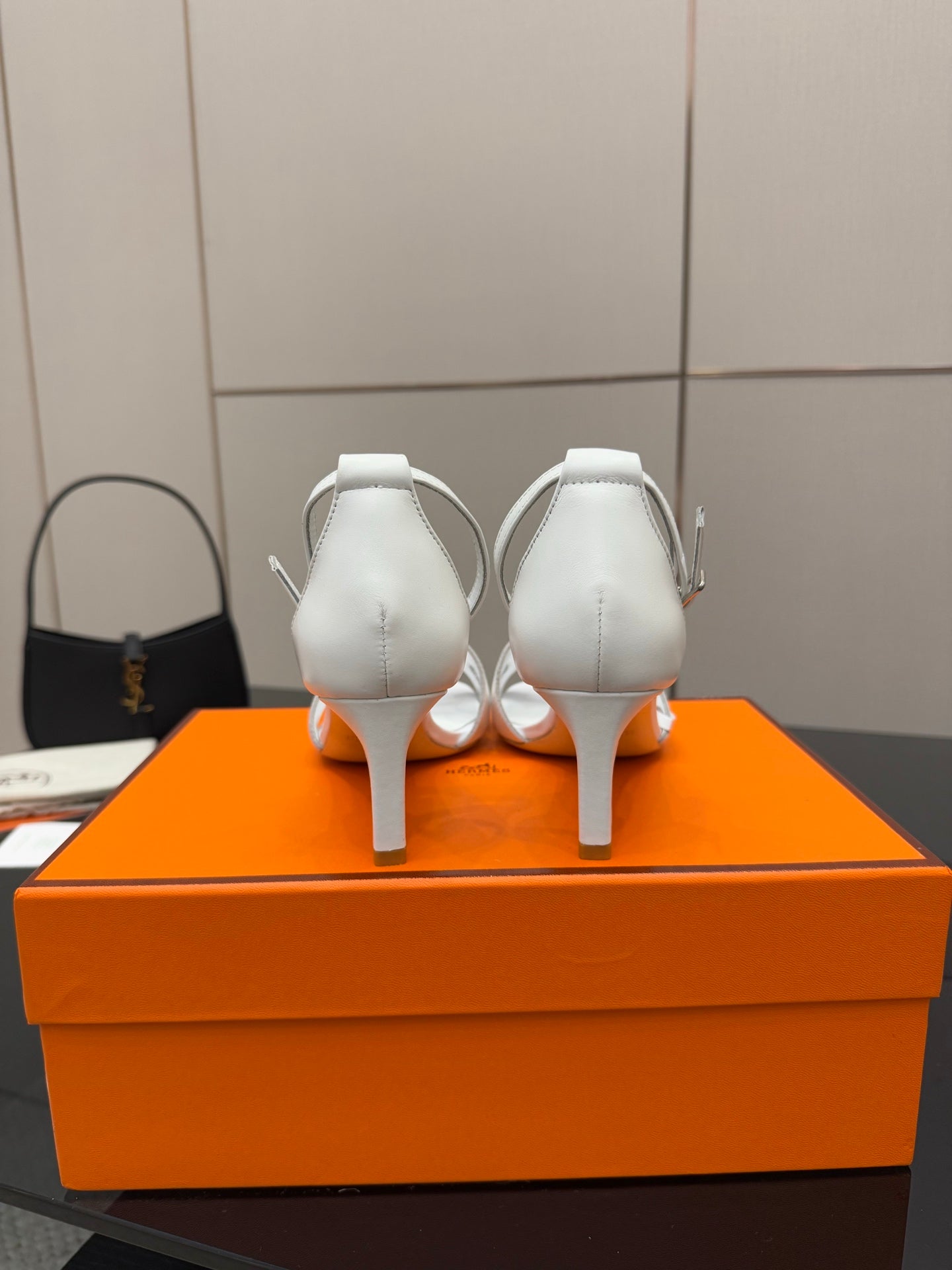 White heeled sandals shown from back, with ankle straps and thin heels