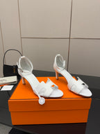 White heeled sandal with slim straps and buckle-style ankle closure