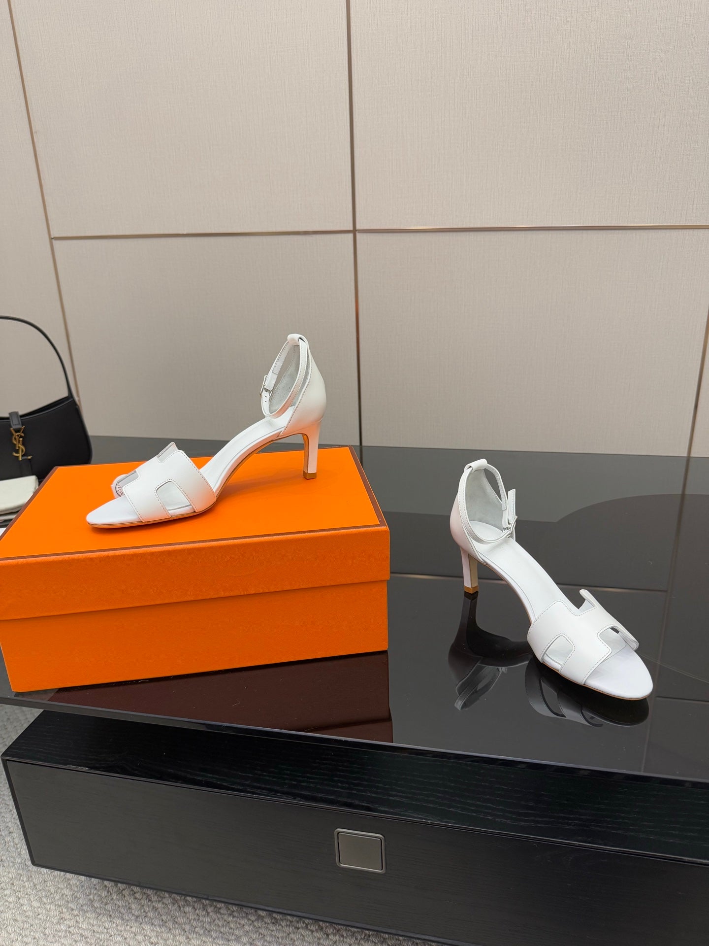 White heeled sandals on display, open toe with ankle strap and cutout straps