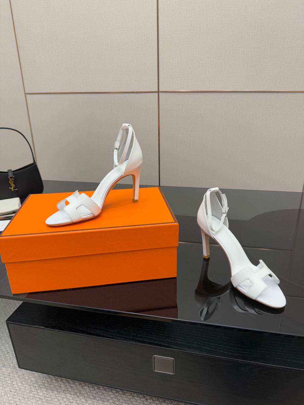 Hermes women's white heeled sandals and heel view on display surface