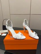Hermes women's white heeled sandals showing side view and ankle strap