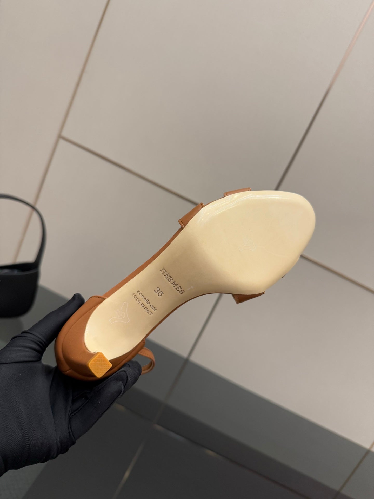 Tan leather sandal outsole with embossed size text, heel view