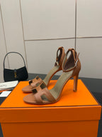 Tan leather heeled sandals set on orange box, showing front and back profile