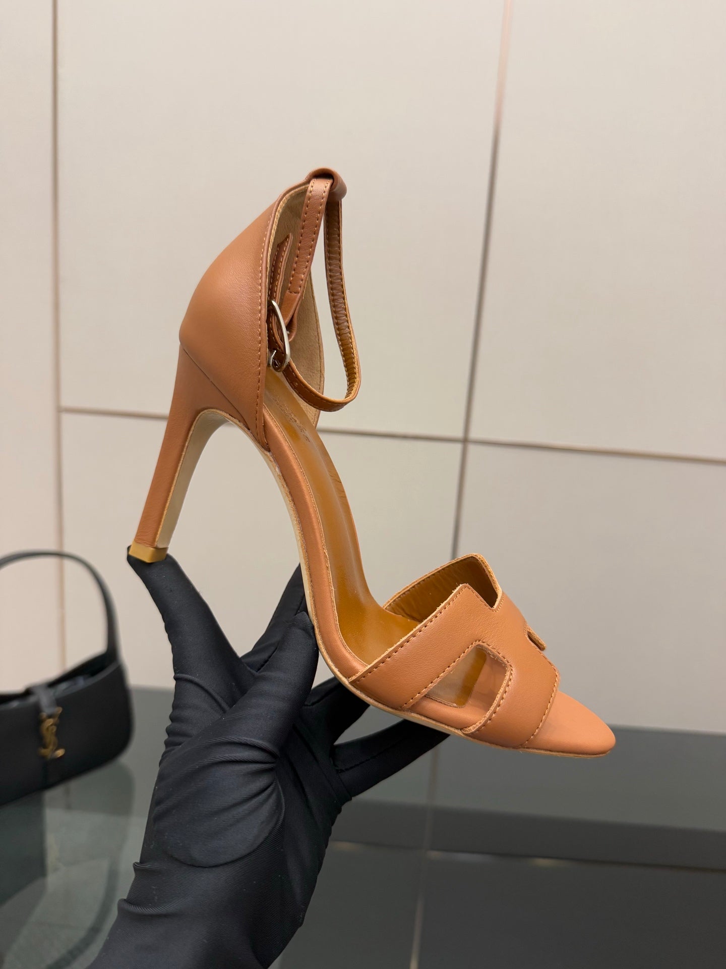 Tan leather heeled sandals held up, with ankle strap and cutout H-style front