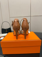 Tan leather heeled sandals viewed from the back, showing heel and slingback strap