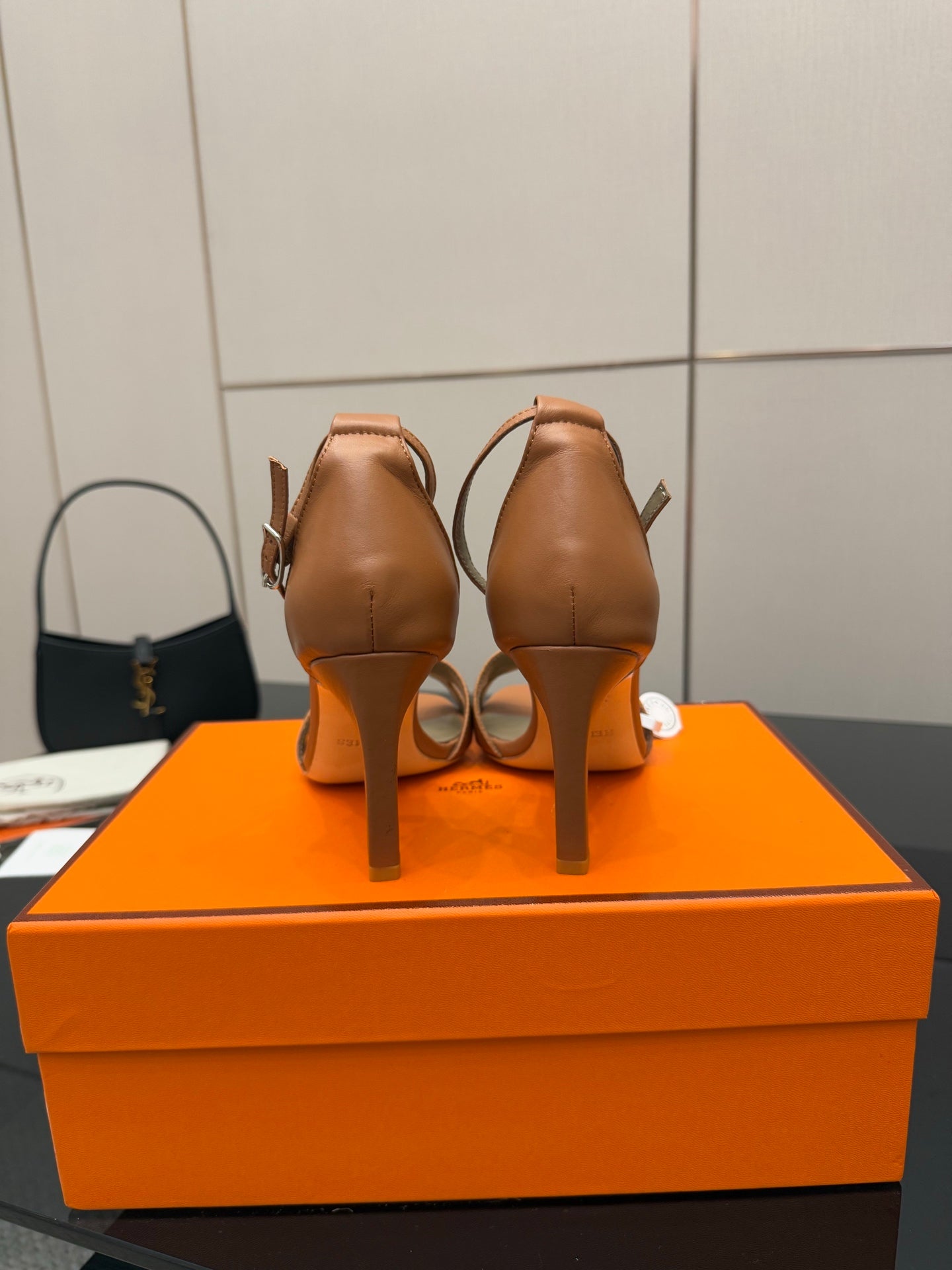 Tan leather heeled sandals viewed from the back, showing heel and slingback strap