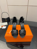 Women's black leather heeled sandals with wide buckle straps and slim stiletto heel