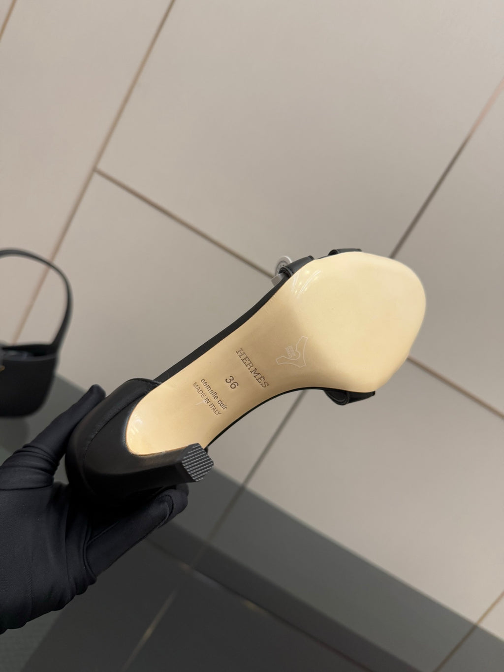 Women's black sandal sole view with molded logo text on outsole