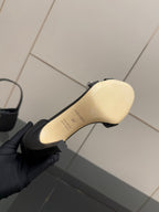 Women's black sandal sole view with molded logo text on outsole