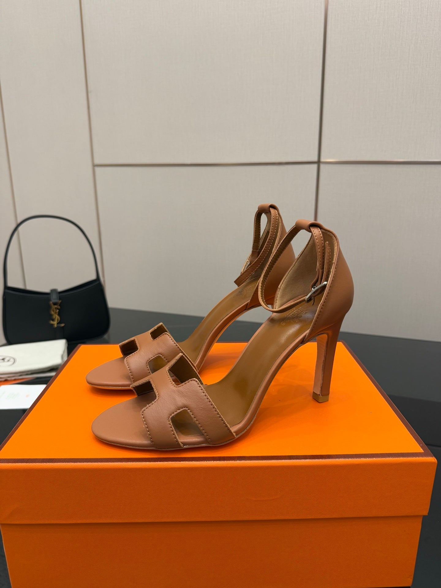 Tan leather heeled sandals with ankle strap, open-toe design, and cutout H front