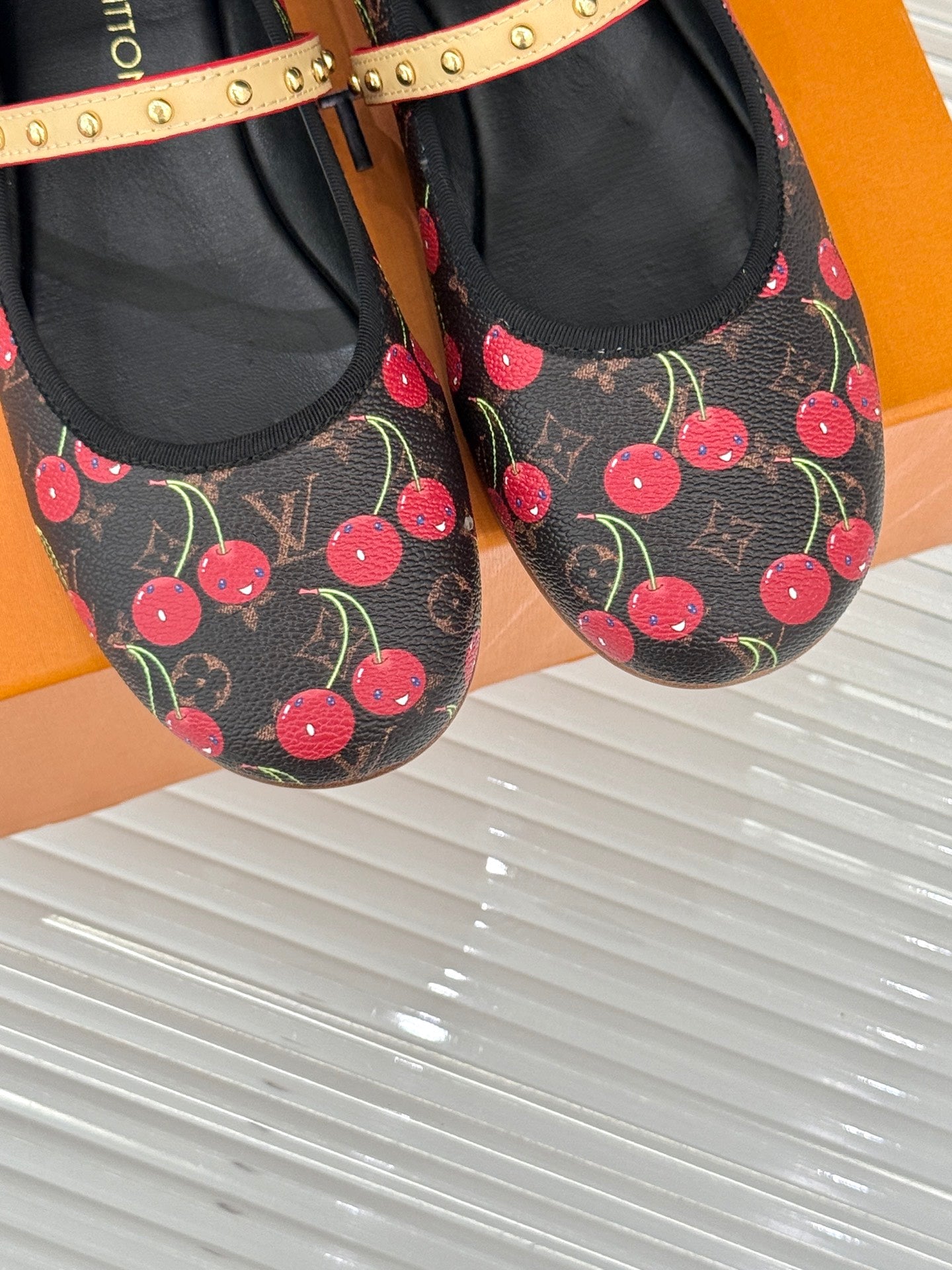 Women's black cherry-print flats with gold studded strap and textured lining