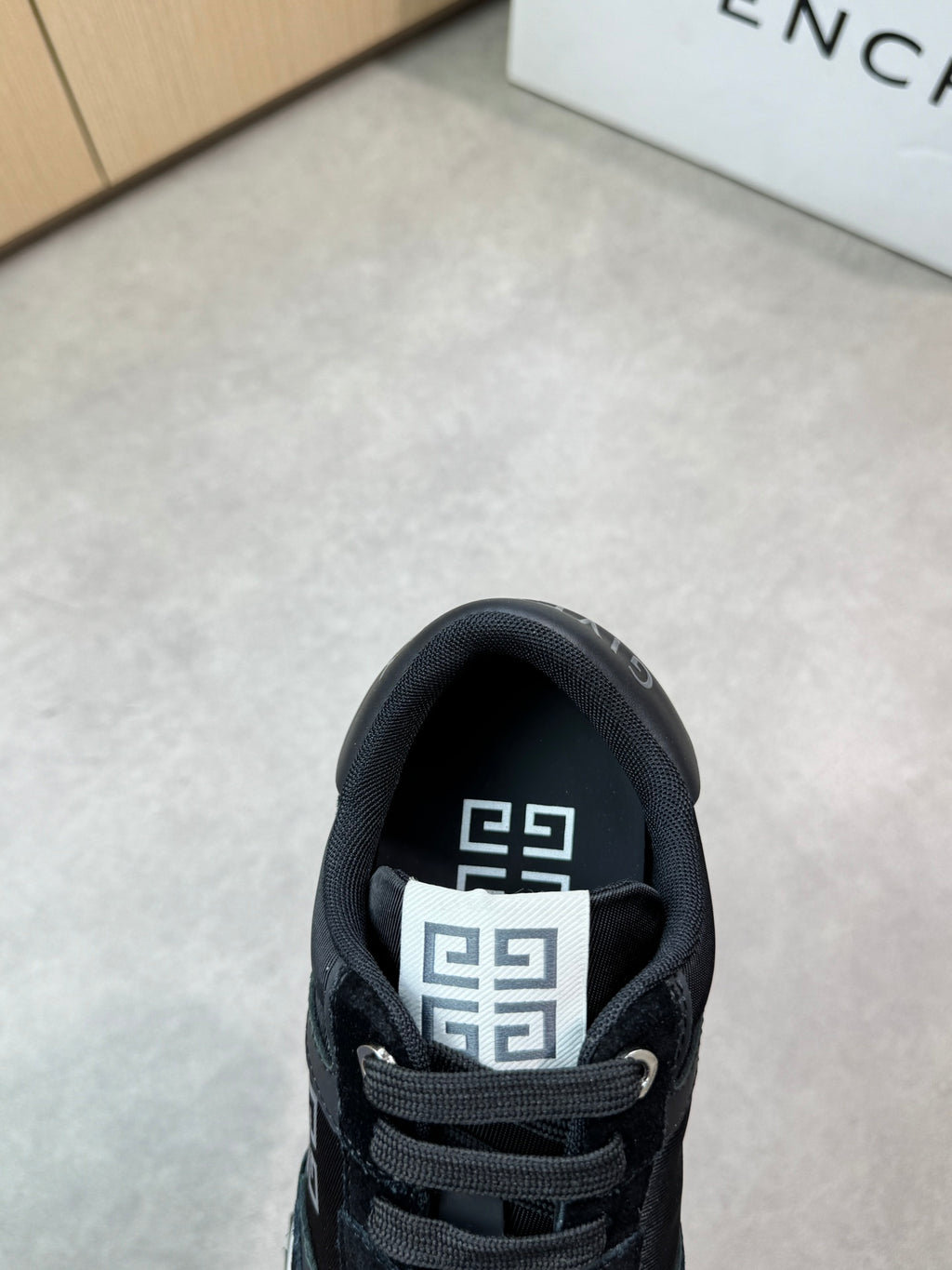 Givenchy black sneakers, close-up of tongue and laced collar with logo patch