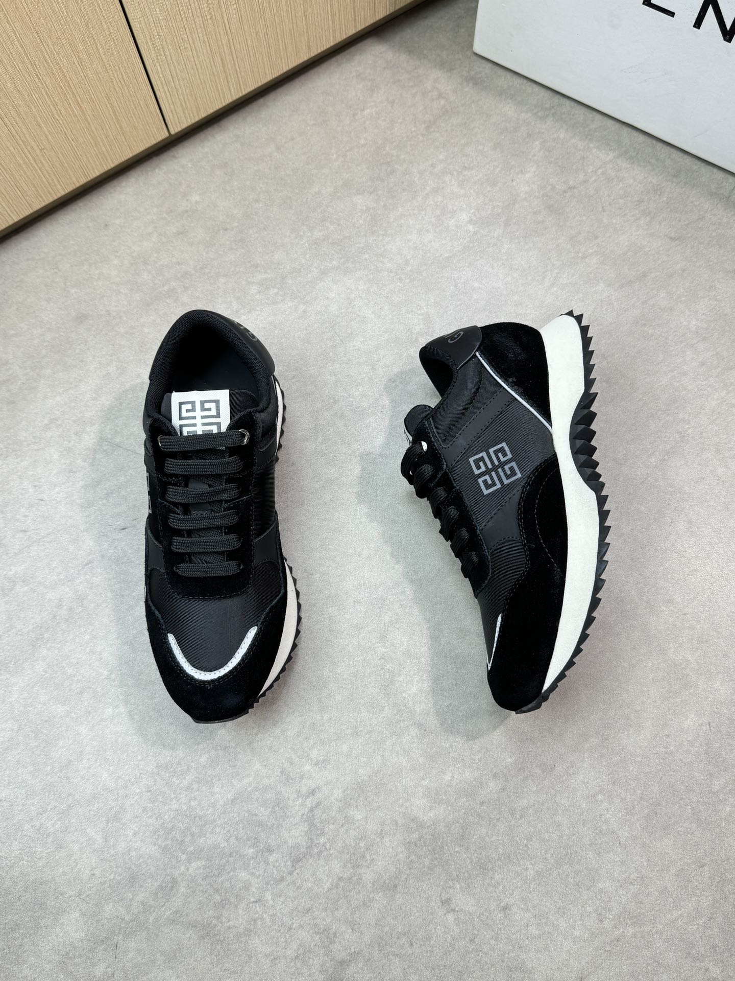 Givenchy black lace-up sneakers, side view with Greek-key logo and white outsole