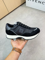 Givenchy black lace-up sneakers held up, side profile with white trim and logo