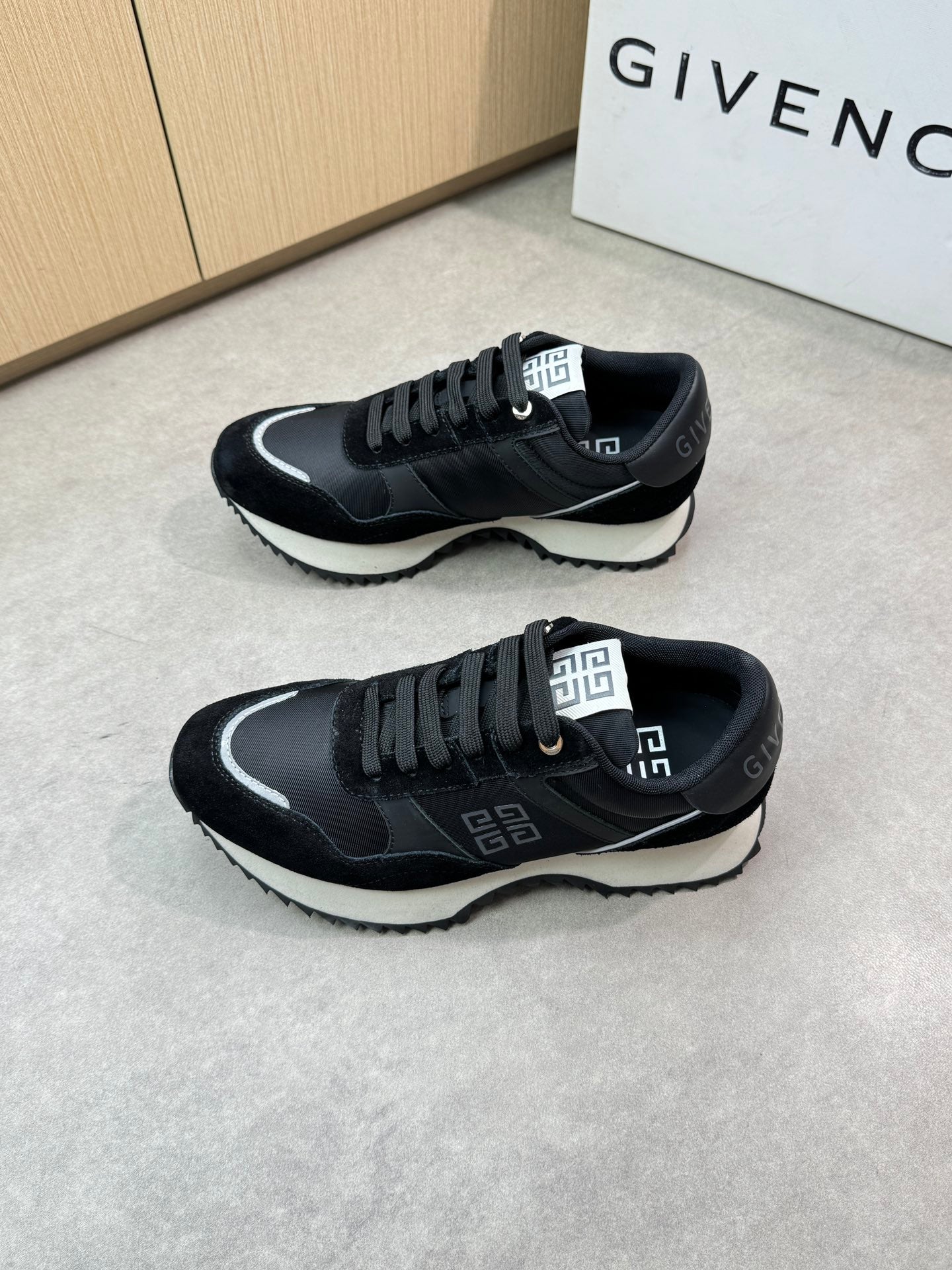 Givenchy black lace-up sneakers, pair front three-quarter view with logo accents