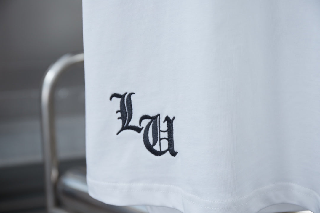 White T-shirt sleeve hem with dark monogram-style logo