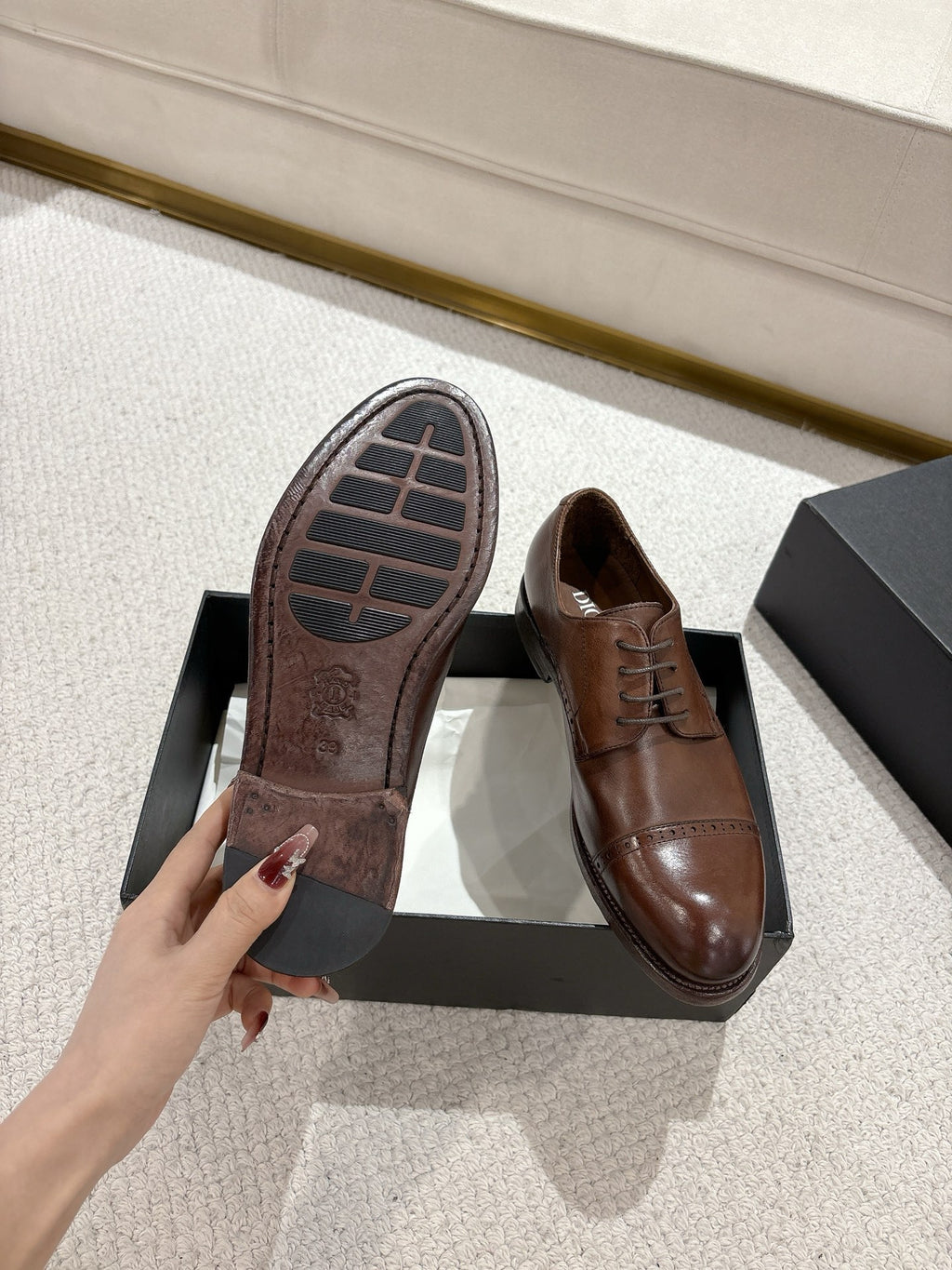 Brown leather lace-up dress shoes showing tread sole, in black box