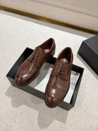 Brown leather lace-up dress shoes with pointed toe, on black shoe box