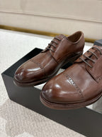 Brown leather lace-up dress shoes with stitched panels, on black box