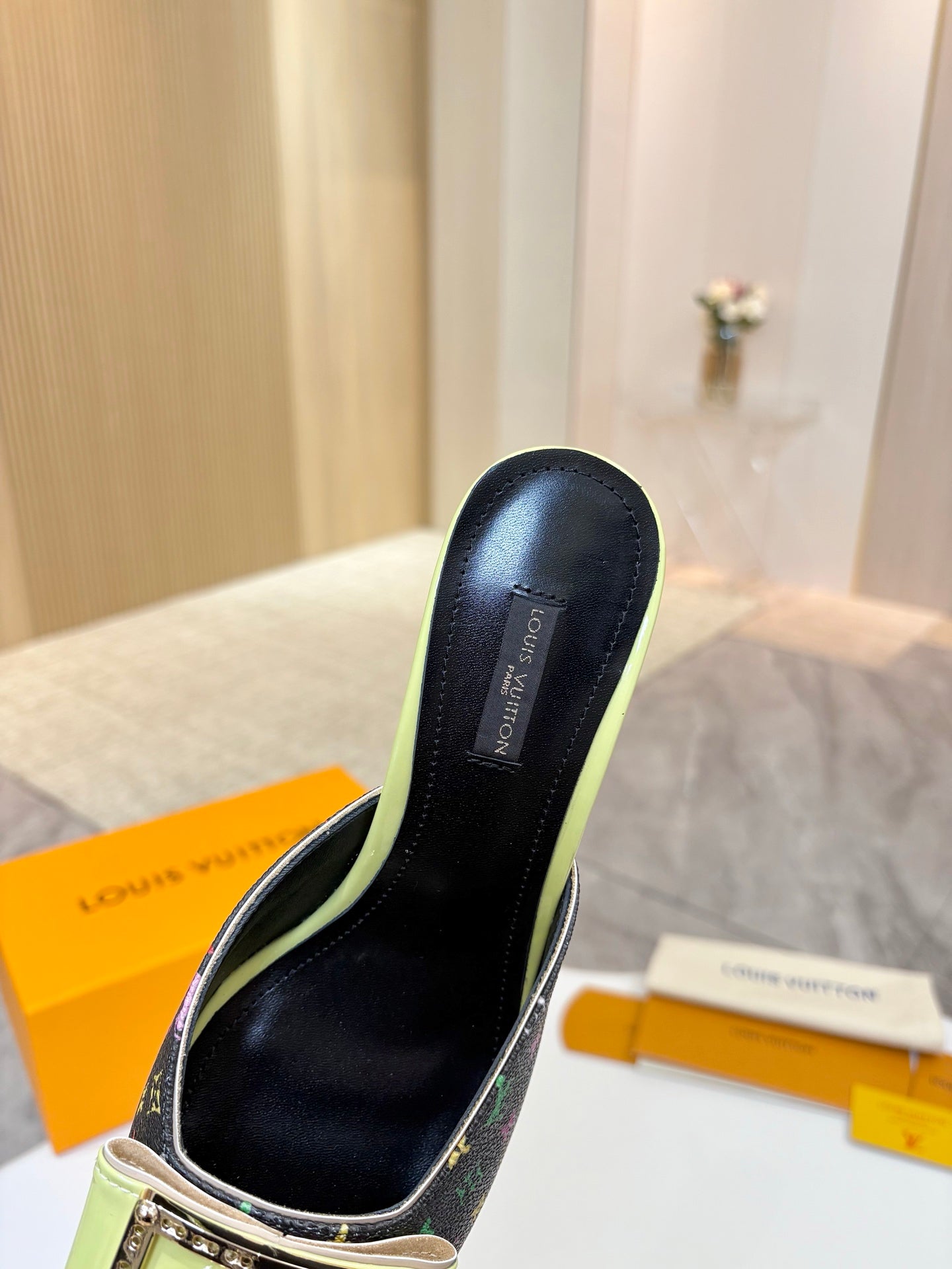 Ladies mule heel interior view with neon green edge and gold buckle strap