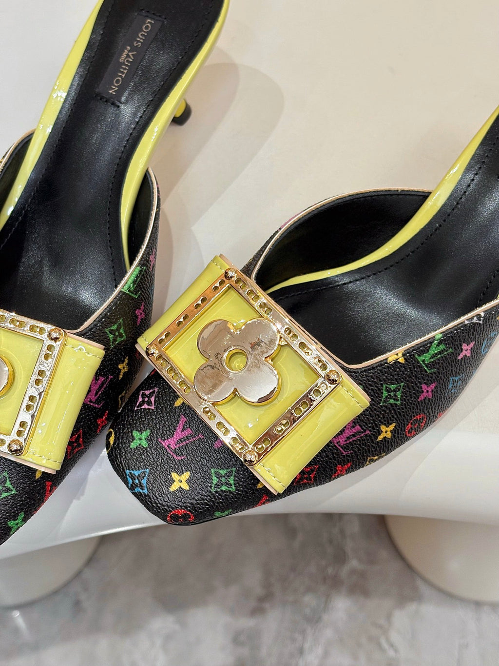 Close-up of ladies mule with gold buckle hardware and multicolor monogram canvas