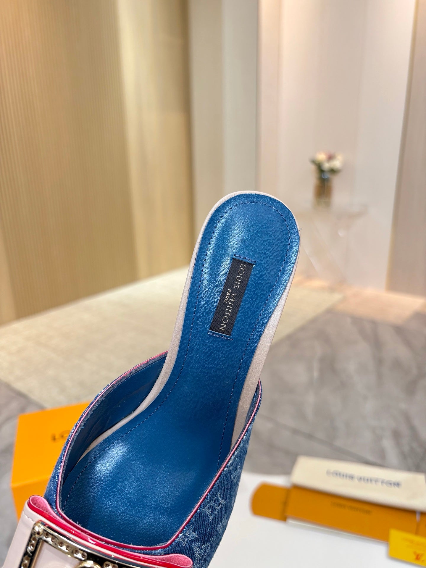 Women's blue monogram mules with open back and gold buckle detail