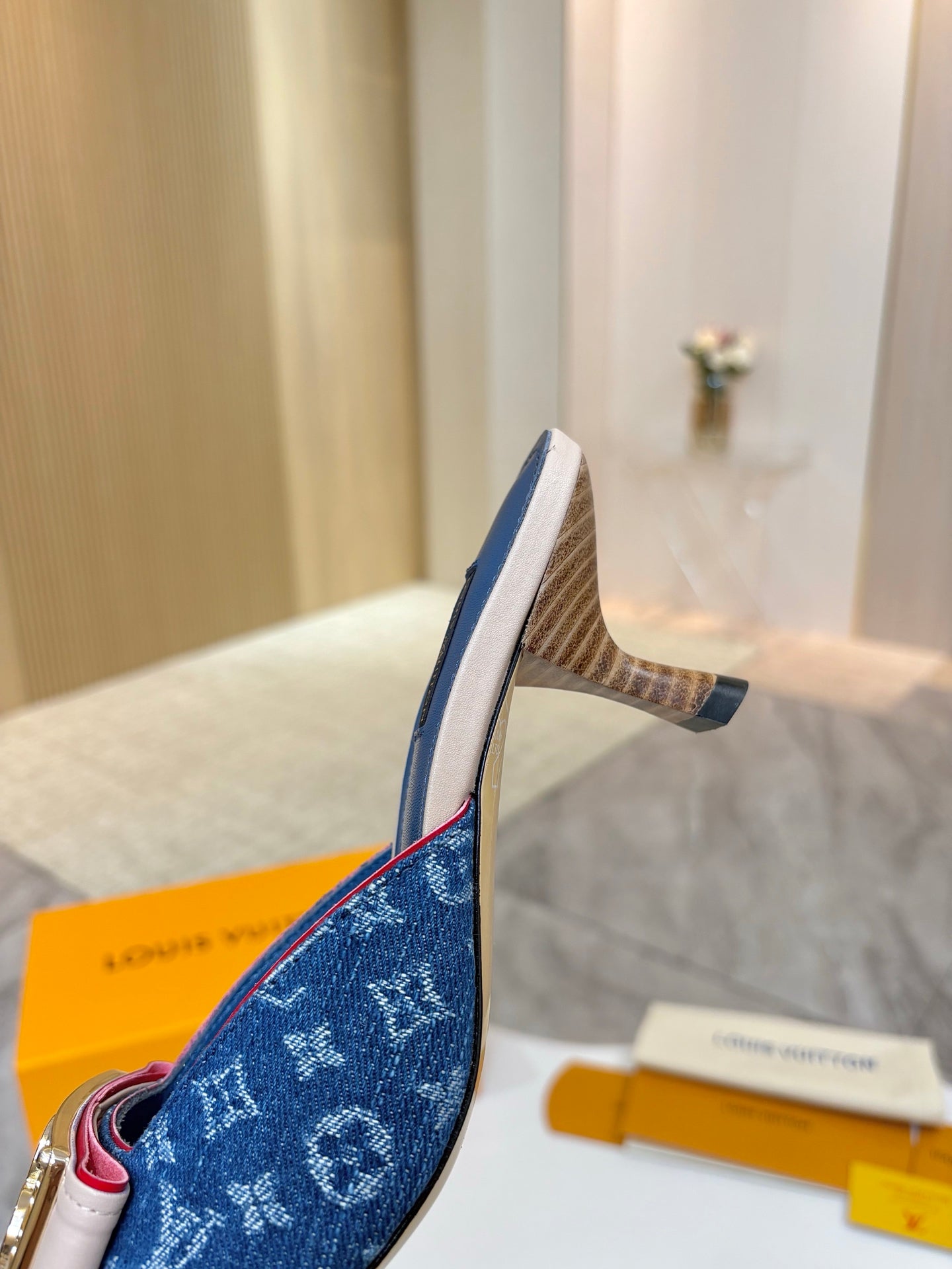 Women's blue monogram mule shoe with heel profile and side buckle