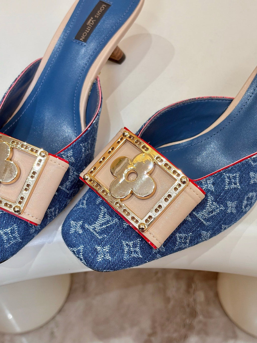 Women's blue monogram mules with jeweled gold buckles and pink trim