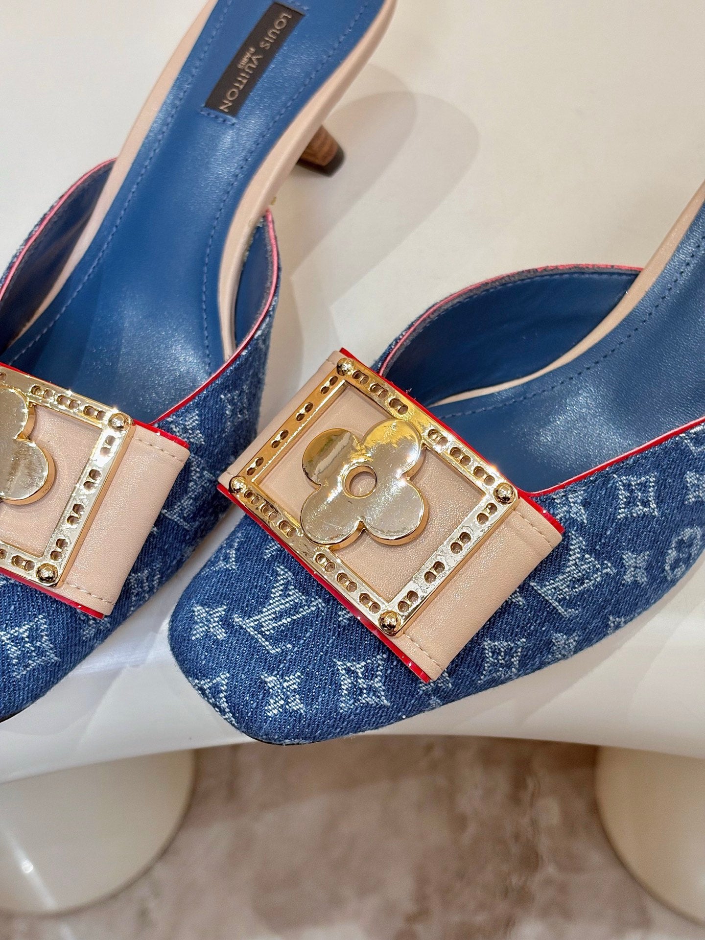 Women's blue monogram mules with jeweled gold buckles and pink trim