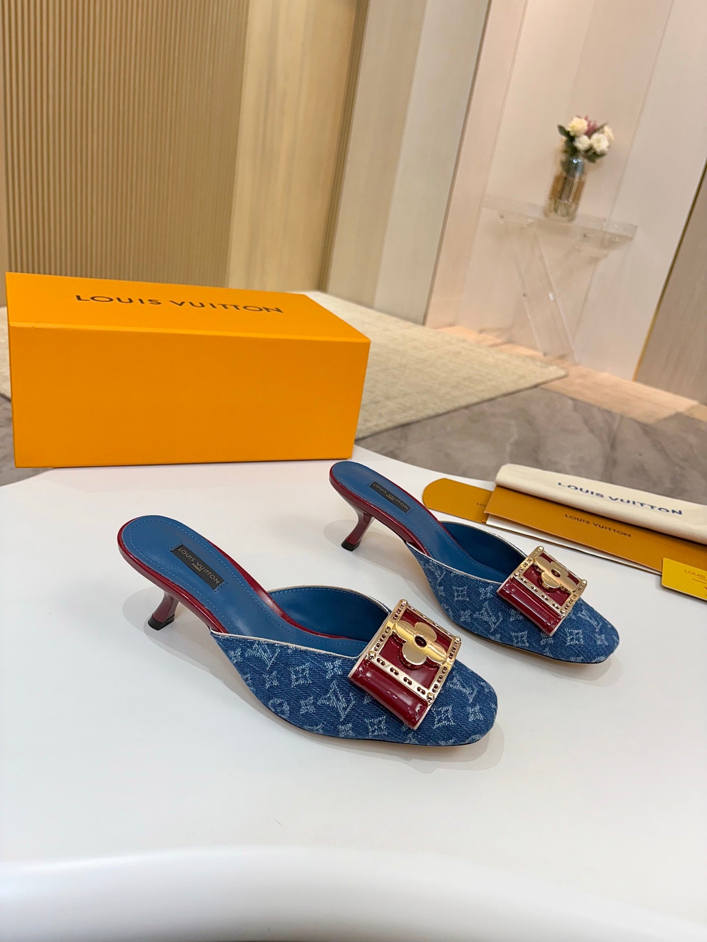 Blue monogram heeled mule pair with gold buckle and burgundy heel caps