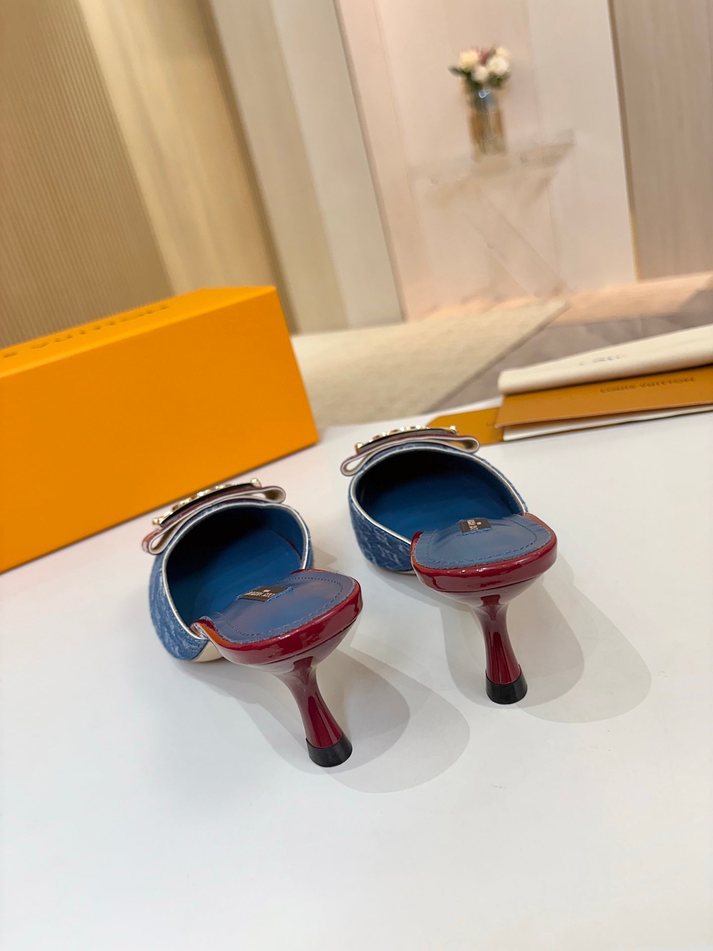 Two blue monogram mules on stiletto heels with burgundy patent trim