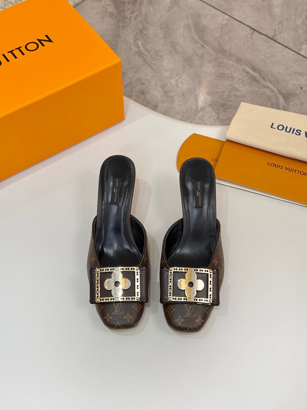 Louis Vuitton women's mule shoes, pair view with gold buckles and monogram uppers