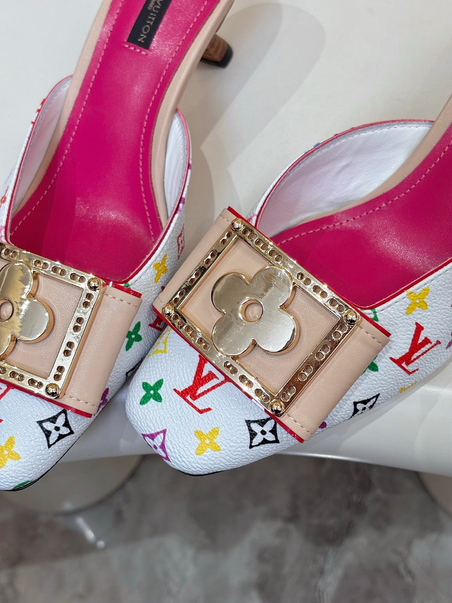 Louis Vuitton ladies mule close-up, gold clover buckle, multicolor monogram strap, pink lining