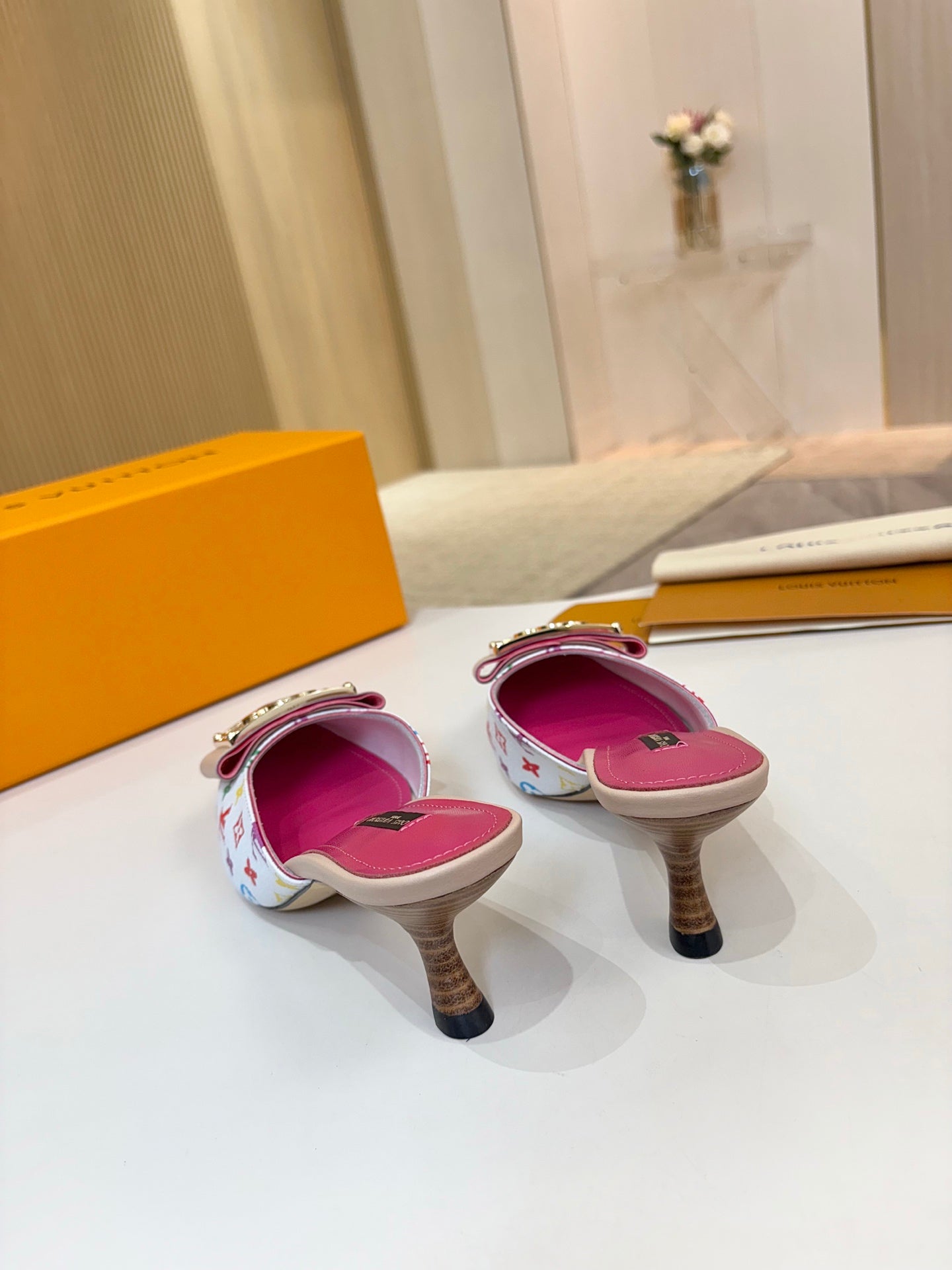Louis Vuitton ladies mules, multicolor monogram slides with pink soles and gold buckles, low heels