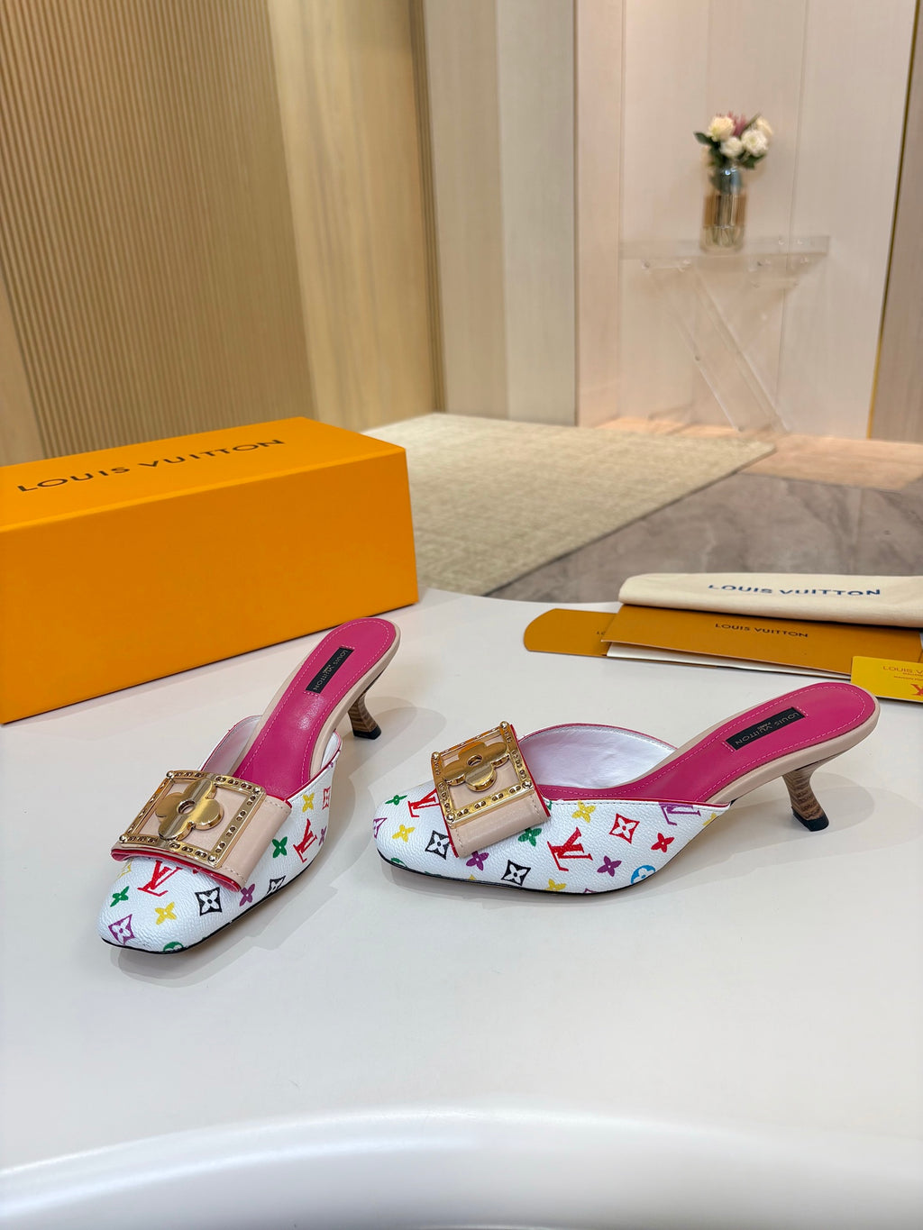 Louis Vuitton ladies mules, multicolor monogram print, gold buckle ornament, pink footbeds, low heels