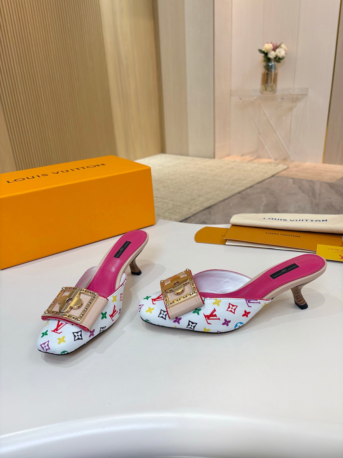 Louis Vuitton ladies mules, multicolor monogram print, gold buckle ornament, pink footbeds, low heels