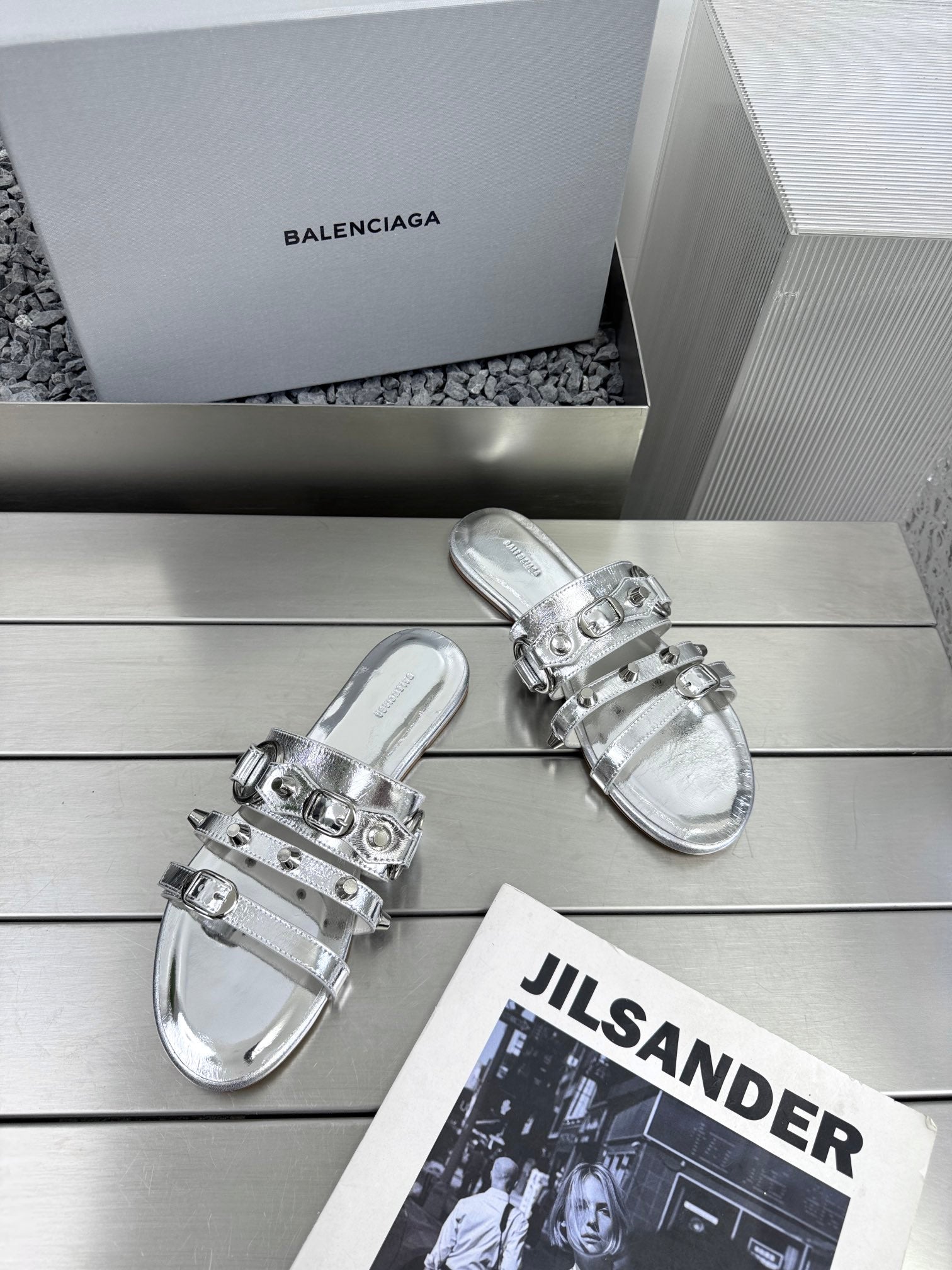 Silver metallic sandals with adjustable buckles and glossy studded strap details