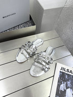 Pair of silver metallic sandals with multi-strap buckles and open toe