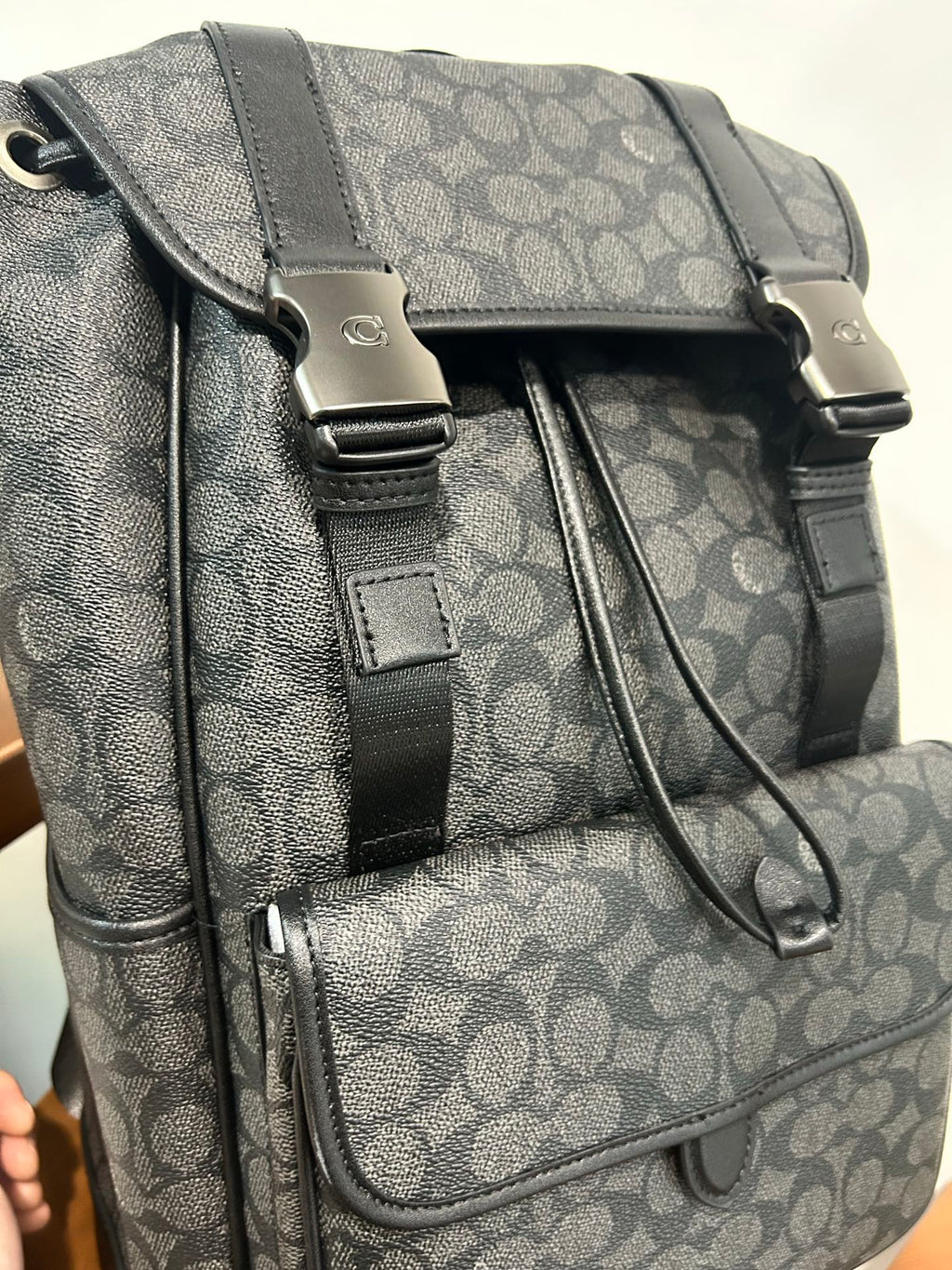 Charcoal monogram backpack close-up with front strap buckles and cord