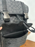 Charcoal monogram backpack close-up of front pocket and crossbody strap