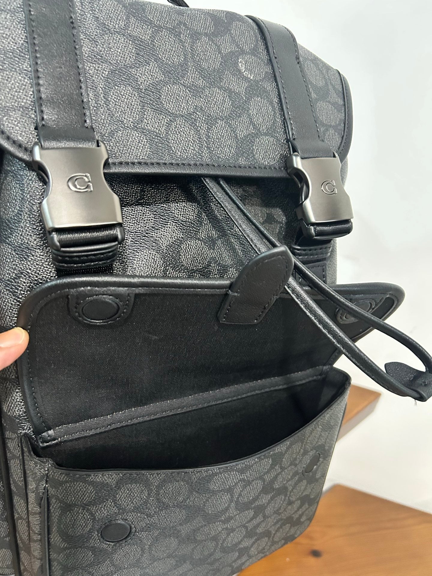 Charcoal monogram backpack close-up of front pocket and crossbody strap