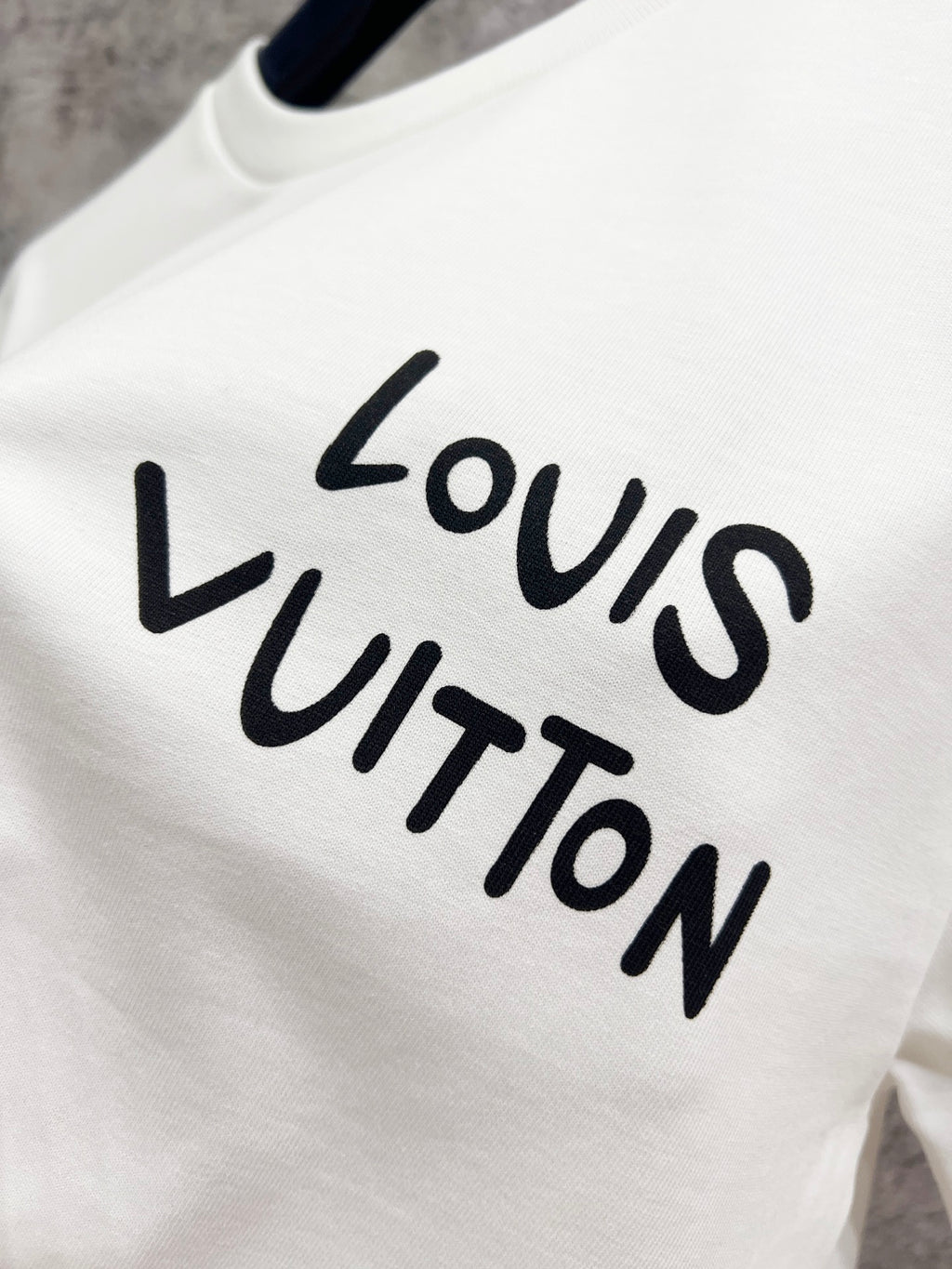 Louis Vuitton white T-shirt, close-up of Louis Vuitton logo print
